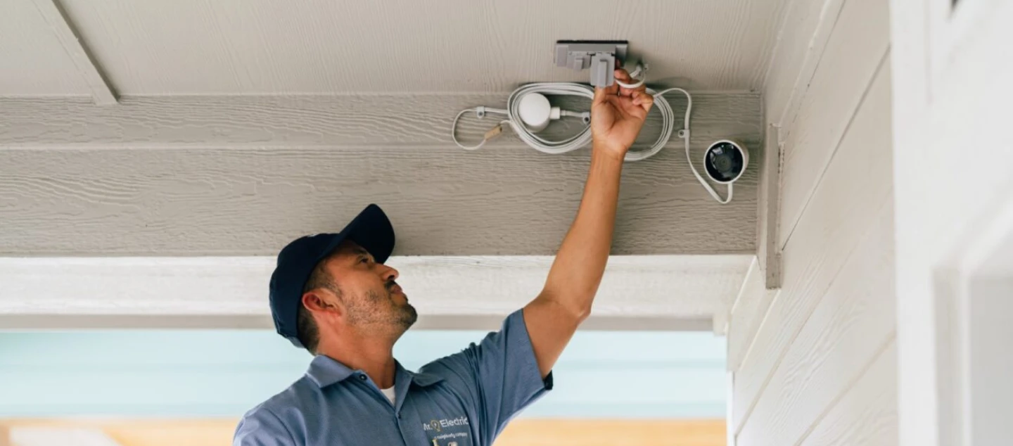 Mr. Electric technician servicing a security camera.